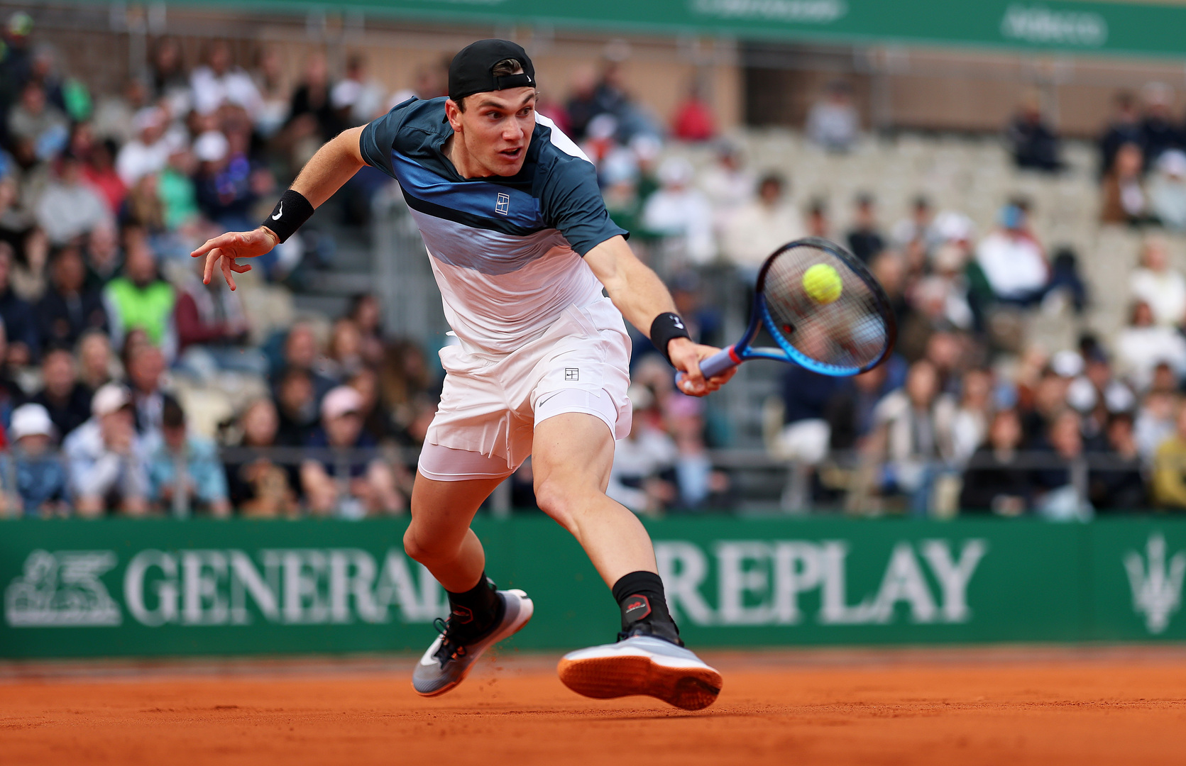 Jack Draper playing a backhand in a tennis match.